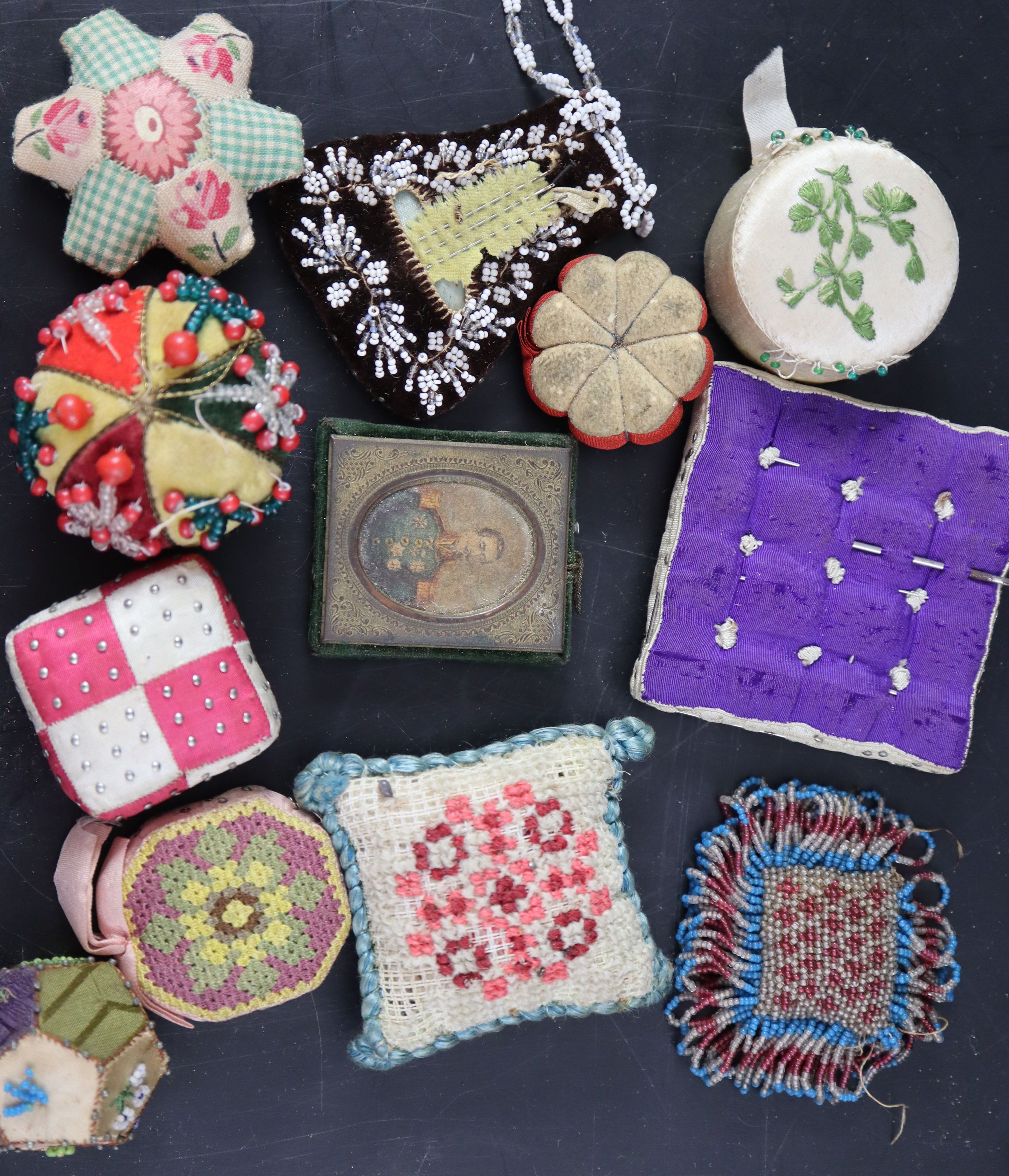 Twelve assorted 19th century fabric pin cushions